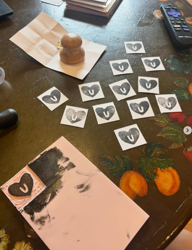 Hand-carved heart stamps and test prints on a worktable